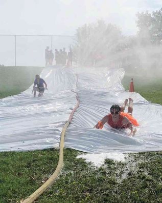 Jacob Snider, Orange House Leader for Sydenham High School’s Grade 9 Day, shows how water sliding is done. 