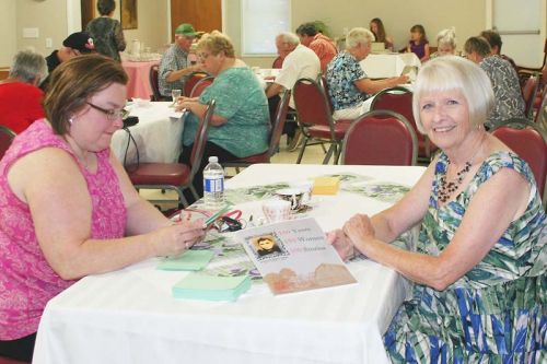 Dianne Lake shows off the 150 years, 150 women, 150 stories book Saturday at the United Church in Sharbot Lake. Photo/Craig Bakay