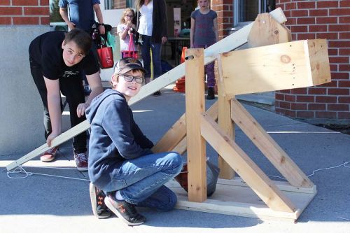 Lucas Steele, a Grade 8 student, created a working trebuchet for the Maker Faire and was assisted by friend Douglas Cook to launch basketballs some 50 feet across the parking lot. Photo/Craig Bakay