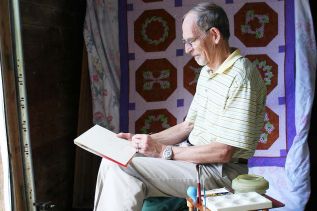 Dave Gilmore, who’s been showing at Art in the Saw Mill since its inception, welcomed visitors as he sketched in the doorway. Photo/Craig Bakay