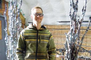 Metal artist Stefan Duerst at his Godfrey studio with two pieces from his Public Totem Series