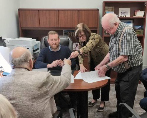 North Frontenac Mayor Gerry Lichty (facing away) Dr. Richard Weldon, Lakelands FHT Executive Director Janice Powell, and Addington Highladns Reeve Henry Hogg, sorting out the paper work in Northbrook on Monday.