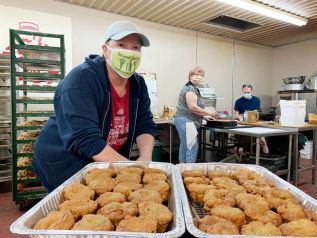 Dawn Lake, owner of Mrs. Garrett’s Bake Shop, shows off some of her deep-fried butter tarts while her mother Joyce and son-in-law Chris work to fill orders for 100 dozen more.