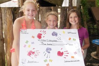 Sydenham Lake Canoe Club members posing wit a massive card that will be presented to Drew.