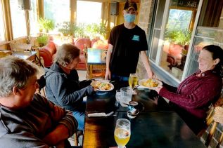 Server Logan Connell delivers supper to Perth Road residents Gerald van Wyngaarden, his sister Wilma van Wyngaarden and Ingrid Uebbing as they enjoy an evening out at Jeff’s Patio at the Holiday Country Manor in Battersea.