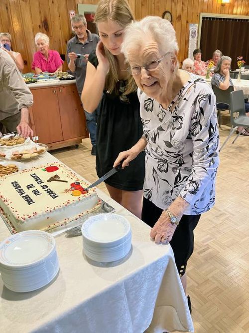 Barb Sproule cutting the celebration cake made by Michelle Ross